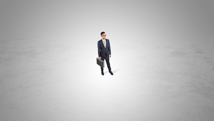 Fototapeta premium Young businessman standing alone in the middle of an empty space 