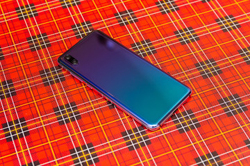 New beautiful flagship smartphone with two cameras in a red gift box on a holiday wrapping paper