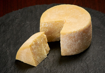 Old weathered cheese on a stone plate