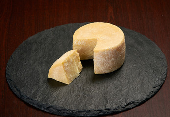 Old weathered cheese on a stone plate