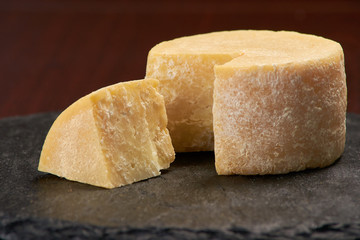 Old weathered cheese on a stone plate