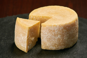 Old weathered cheese on a stone plate