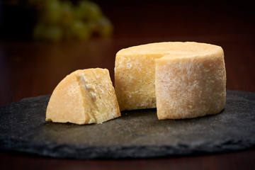 Old weathered cheese on a stone plate