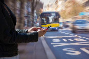 Woman using cellphone and crossing the street.