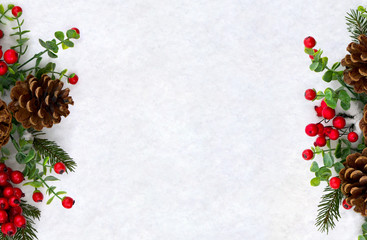 Christmas decoration. Twigs christmas tree, brown natural pine cones and red berries on snow with space for text. Top view, flat lay