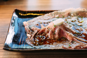 Touched medium rare sliced authentic A5 Grade Japanese Wagyu beef sushi topping with fresh garlic. 