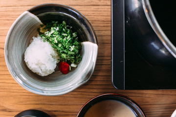 Top view of Shoyu Ponzu (Citrus soy sauce) with minced daikon and scallion.