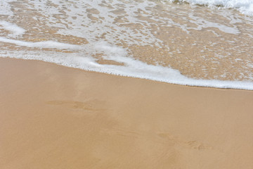 Sea foam on golden sand