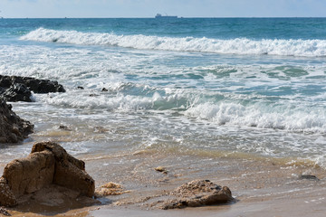 Fototapeta na wymiar Beach, blue waves with white foam, summer day