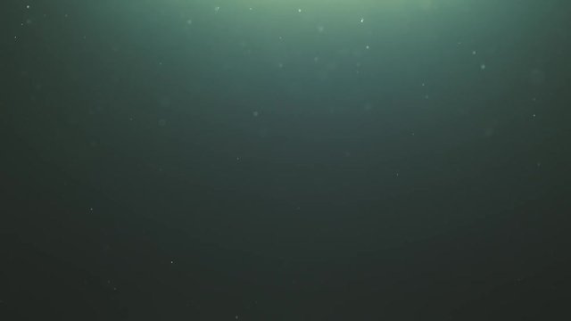 natural teal particles floating in slow motion over black background