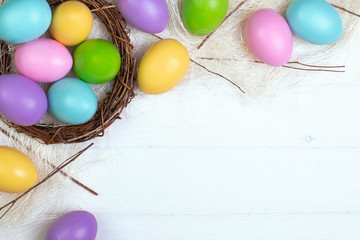 Multi-colored easter eggs in a nest on a white background