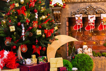 Christmas green fir-tree decorated with toys and a fireplace