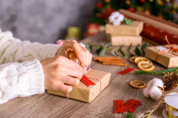 Close up shot of woman prepearing for winter holiday season at her workspace, wrapping christmas...