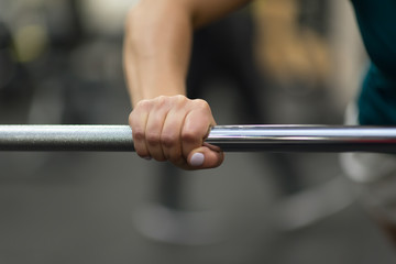 Fototapeta na wymiar Closeup of female hand holding rod neck. Weightlifting, power lifting or cross fit training.