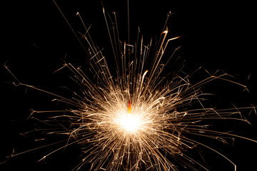 Obraz premium Glittering burning sparkler on Christmas Day and on New Year Day
