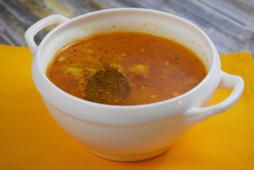 Delicious homemade soup from fresh cabbage on a wooden background.