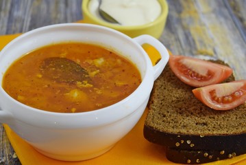 Delicious homemade soup from fresh cabbage on a wooden background.