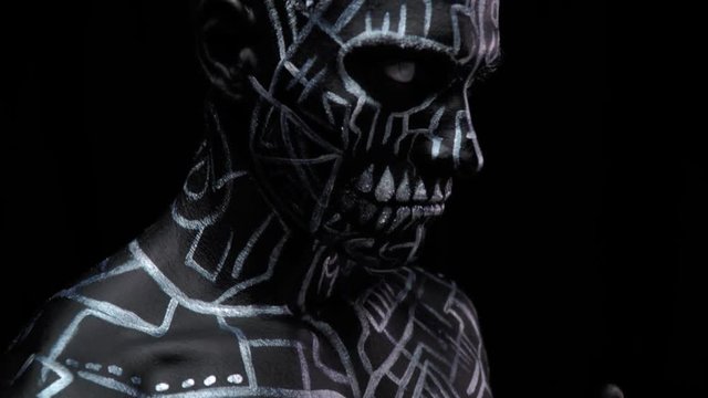 Athletic man with amazing body art, lines and symbols on his body and face