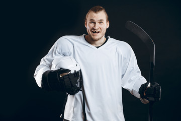 Handsome hockey player smiling at camera with one missing tooth, asking the supporters if there is...