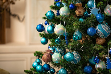Christmas tree with blue and white toys in the interior. Christmas card with white and blue decor