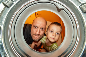 Portrait of father and son view from washing machine inside. What is that thing inside the washing machine?