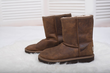Winter brown boots on white fur. Fashion concept