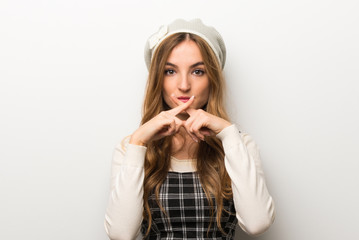 Fashionably woman wearing hat showing a sign of silence gesture