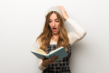 Fashionably woman wearing hat surprised while enjoying reading a book