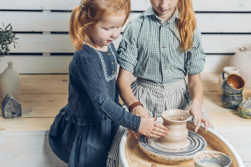 adorable kids is in the workshop of making pots. close up cropped shot