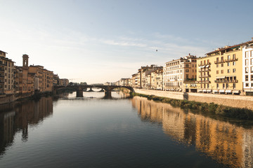 Fototapeta na wymiar River Arno in Florence, city landscape in a sunny day with views from Ponte Vecchio. Landscape of the Arno River and Florence, Italy