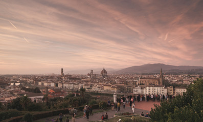 Fototapeta na wymiar Panoramic landscape of Florence, Italy with a beautiful red sunset and tourists on the viewground. Florence on a beautiful sunset, with an unreal red sky.
