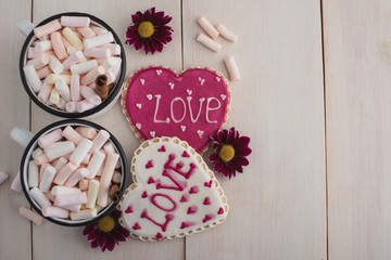 Romantic breakfast for valentine day. A delicious drink of marshmallows and heart-shaped cookies. Breakfast for lovers on pink textile