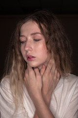 The portrait of a young girl with blonde hair isolated on a brown background