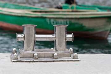 Mooring bitt on jetty against fish boats
