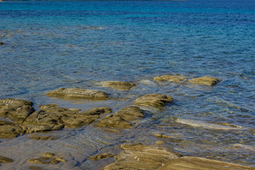 rocky south beach and underwater stones look up above vivid blue sea bay water surface, local wallpaper landscape with empty space for copy or your text