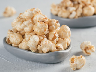 popcorn in gray craft trendy plate on gray concrete background. Moovie background with copy space. Top view or flat lay.