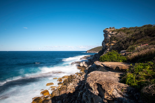 Long exposure waves and cliffs at head lookout. Manly walking trek. Australia
