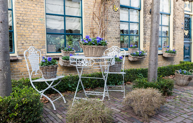 old metal chairs and table in front garden 