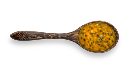 passion fruit in wood spoon isolated on white background. top view