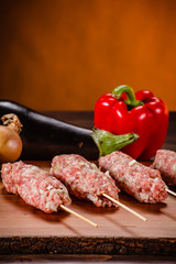 Raw hot dogs on cutting board and vegetables