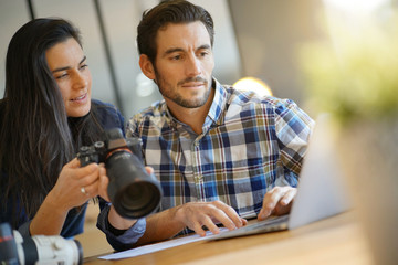 Photographer colleagues going through photos on camera