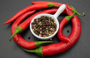 Red chili peppers with mixed peppercorns in a white bowl