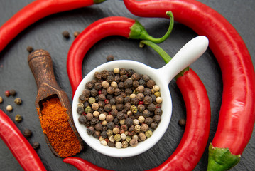 Red chili peppers with mixed peppercorns in a white bowl