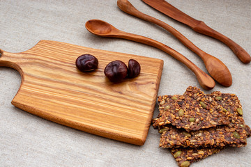 Toasts of grain and seeds and chestnuts on a wooden Board with wooden spoons.