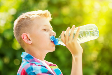 Portrait of a young boy drinking a bottle of water