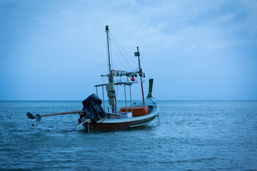 Thai fishing boat parked in the sea evening blue sky.
