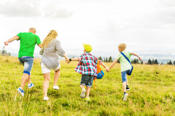 Family is walking together around the hill