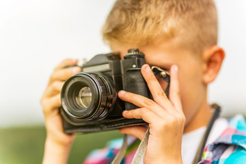 Young blonde boy holding a camera