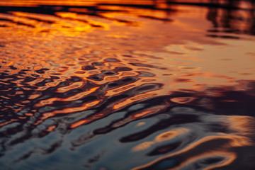 Water background with smooth ripples during sunset