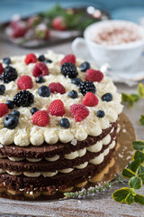 Celebratory cake with berries and a cup of aromatic coffee